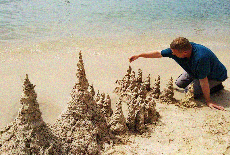 Danny Dorling building drip sandcastles in Wales